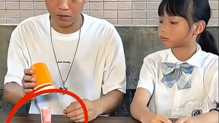 给女儿表演绝技。空杯变钞票。