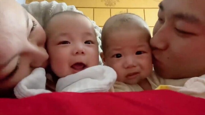 The adorable reactions when twin babies each get a kiss on the cheek from their mom and dad—and what