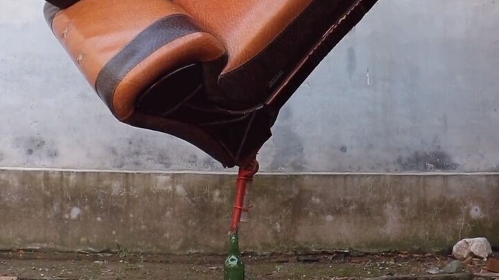 Seni menjaga keseimbangan: sofa kulit ditambah kunci inggris, botol kaca untuk menopang.