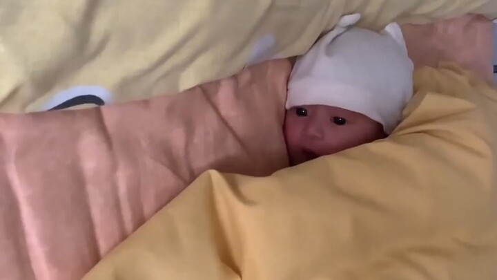 A 15-day-old baby, quiet and calm, wide-eyed and hiccuping!