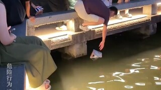 女生手里的袋子掉水里，路过男生帮忙捞起来，没想到袋子遇水破掉