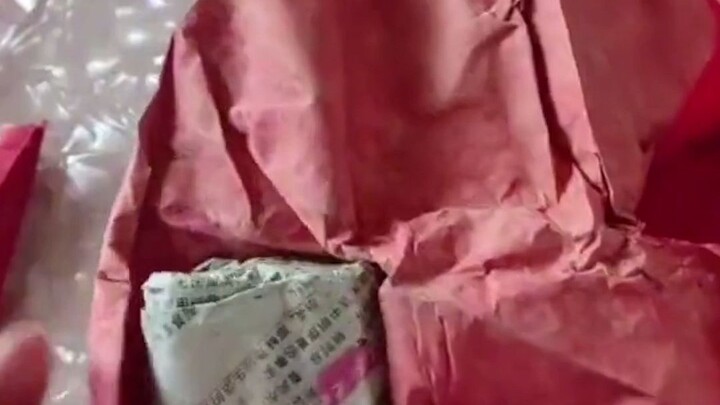 Seorang pria membuka amplop merah yang telah disiapkan neneknya untuknya untuk pernikahannya lebih d