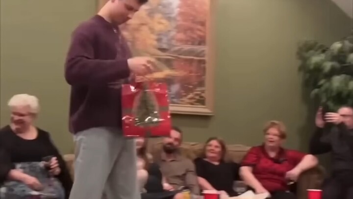 A man received a Christmas gift from his grandma and immediately put it on to show off to everyone.