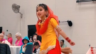 A cute little girl performing Indian dance at a festival