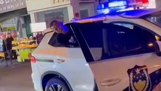 男子喝醉了坐在警车上唱歌，警察小哥一把把他头从车窗按回去了