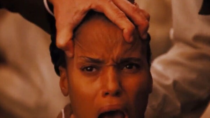 A white man gently saws open a Black man’s skull, revealing three distinct indentations on the insid