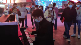 A boy playing the theme song of Sword Art Online on the street