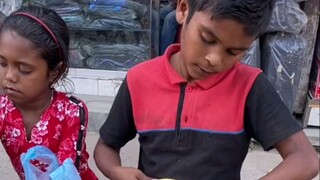 A pair of little brothers and sisters selling pineapples on the street