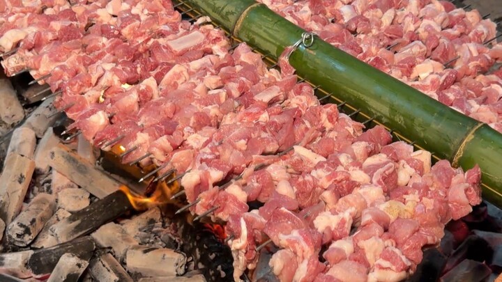 Ordinary skewers just aren’t satisfying—how about a giant barbecue with a banana‑leaf fan?