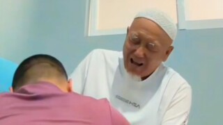 Seorang pria tua berjanggut putih sedang menerima pijatan