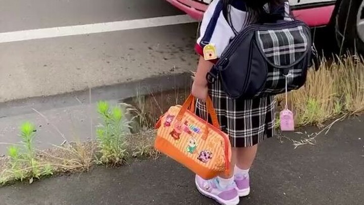 A cute little kid in Japan is the epitome of good behavior on the school bus—so adorable!