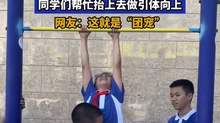 Cậu bé nhảy lên mãi vẫn không với tới xà đơn, các bạn cùng lớp bèn đỡ cậu lên để thực hiện động tác 