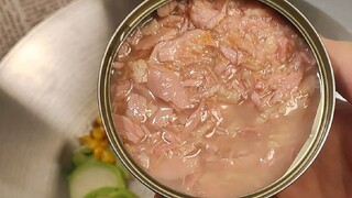 Pria tangguh menggunakan makanan kaleng untuk membuat nasi