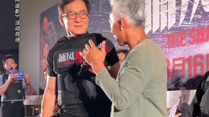 64-year-old guy flexes his muscles in front of 71-year-old Jackie Chan...