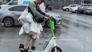 这位牛人想用电动滑板车，运走一购物车的东西，里面还有个大西瓜