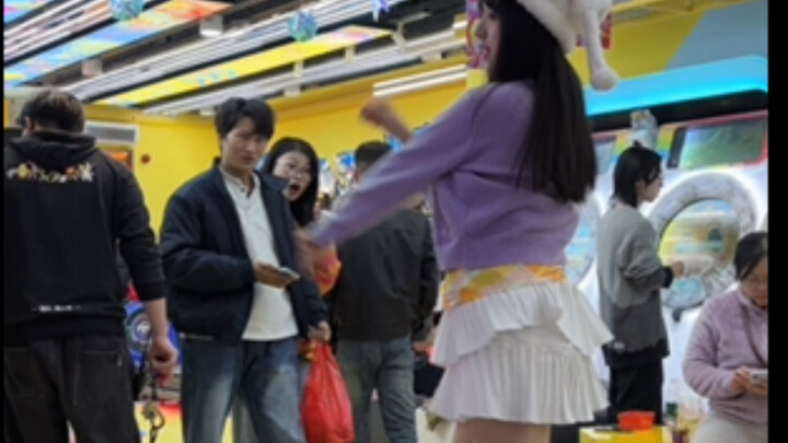 يا له من حشد كبير! لا مجال للتوتر هنا: فتاة رائعة بتنورة بيضاء قصيرة ترقص على آلة الرقص بثقة وانطلاق