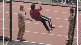 Saat latihan militer, seorang siswa laki-laki melakukan pull-up dengan gaya keren. Semula dikira itu