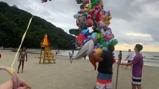 很有商业头脑的大叔，在海边这样卖气球。不用吆喝不用到处走，气球已经飞上天招揽顾客了