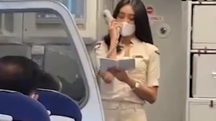 Seorang pria terkesima oleh pramugari di penerbangan luar negeri. Ia mengenakan baju lengan pendek, 