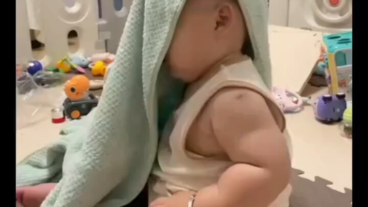 The baby, wrapped in a little towel, listens to mom’s scolding, thinking they’re reflecting—only to 