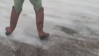 在冰天雪地里穿着靴子的妈妈，自创了一种走路方式