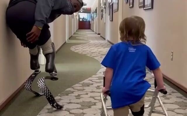 Bocah laki-laki yang kehilangan satu kaki dan menggunakan kaki palsu, dengan dorongan dari seorang a