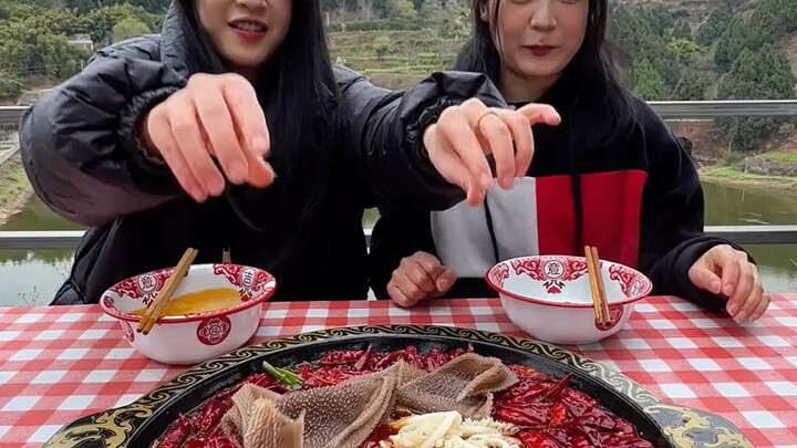 Two junior sisters eating hot pot