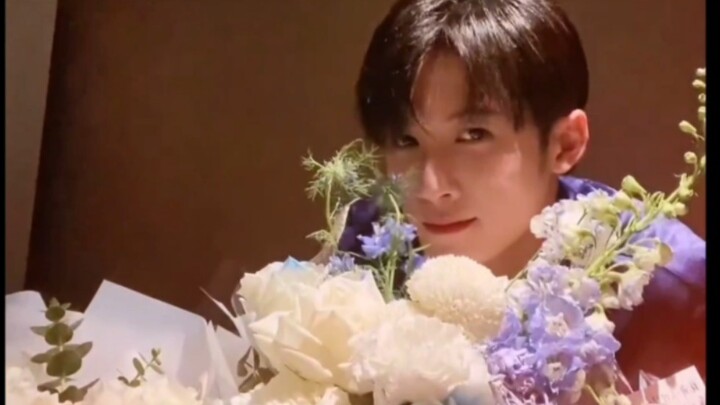 This is a video of Tan Jianci taking a photo with flowers sent by fans during the filming of "Huntin