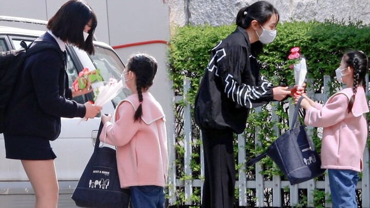 小女孩送花给路人并送上祝福，收到花后人们的反应是？