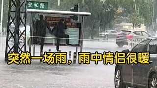 Suddenly it started raining, and the couple in the rain looked so warm.