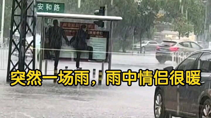 Suddenly it started raining, and the couple in the rain looked so warm.