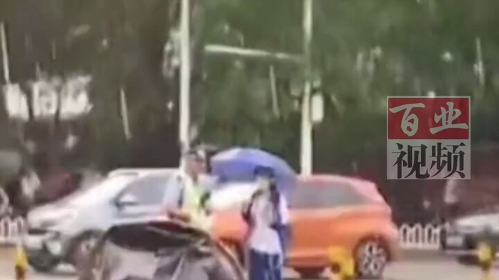 Học sinh trung học che ô cho cảnh sát giao thông khi chờ đèn đỏ, thật là một em bé ấm áp, xin dành t