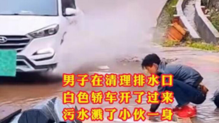 男子在清理路面排水口，白色轿车开了过来，污水溅了小伙一身！