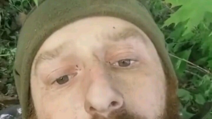 An injured Ukrainian soldier lies alone in the woods, weakly filming a plea for help. He says his co