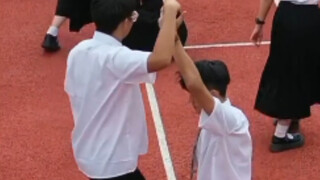 Dua siswa laki-laki menari waltz di kampus