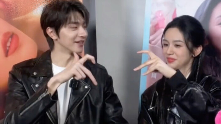 Zhou Ye and Lin Yi make heart signs with their index fingers.