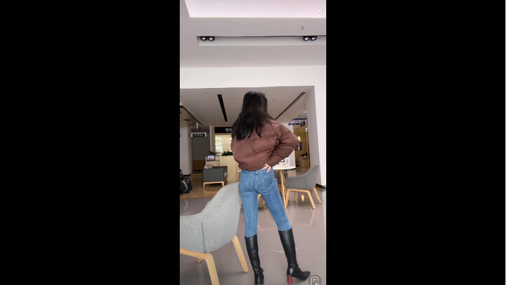 The girl in jeans shows off her sexy back on the catwalk