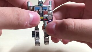 Seorang siswa sekolah menengah yang tidak punya uang mengevaluasi model kertas G1 Ultra Magnus buata