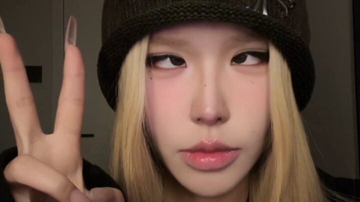 Yellow-haired girl rolls her eyes and gives a thumbs-up