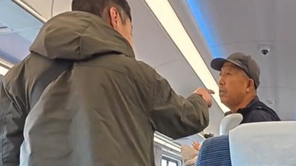 A Northeastern man on a train tries to persuade another Northeastern man to keep his voice down, but