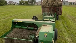 一台自动收集、捆扎干草的机器，扎好了还会扔到后面的车厢...怪可爱的！