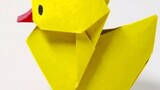 The origami little yellow duck, which is said to bring good luck, is folded and placed on the table,