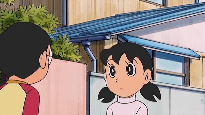 Nobita dùng miếng kẹo cao su thần kỳ để nếm thử món ăn thơm ngon trong miệng mọi người