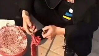 Seorang pria tak bisa memutuskan sumbu mesiu petasan, lalu temannya di sampingnya menyerahkan korek 