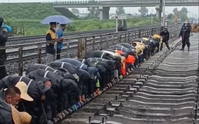 Semua orang bekerja sama untuk mengangkat rel