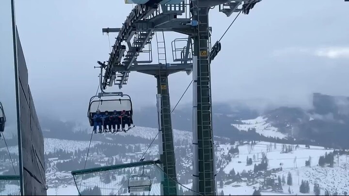 Young Skiers Sing On Chair Lift