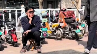 หลานชายช่วยคุณยายนั่งขายต้นหอมจีน โดยถือเก้าอี้มานั่งเป็น "ตัวประกอบ" ข้างๆ แต่ถูกคุณยายที่เดินผ่านม