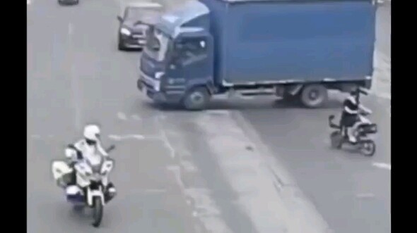 امرأة تقود دراجتها وتعبر الطريق بشكل غير قانوني، فتُطبِّق الشاحنة مكابح الطوارئ لتجنبها.