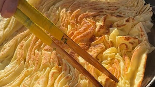 Những chiếc bánh xèo có hương vị hành lá và nước sốt trên đường phố Đại Khánh mềm và thơm, được phủ 