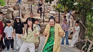 At Kaifeng Wansuishan, a young woman learns the "head-chopping dance" from an older sister, with con